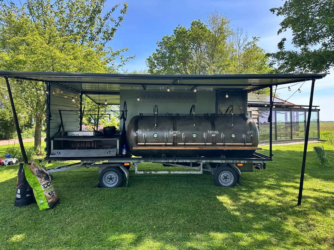 De grote smoker El Patron del Assado op een aanhanger in het gras