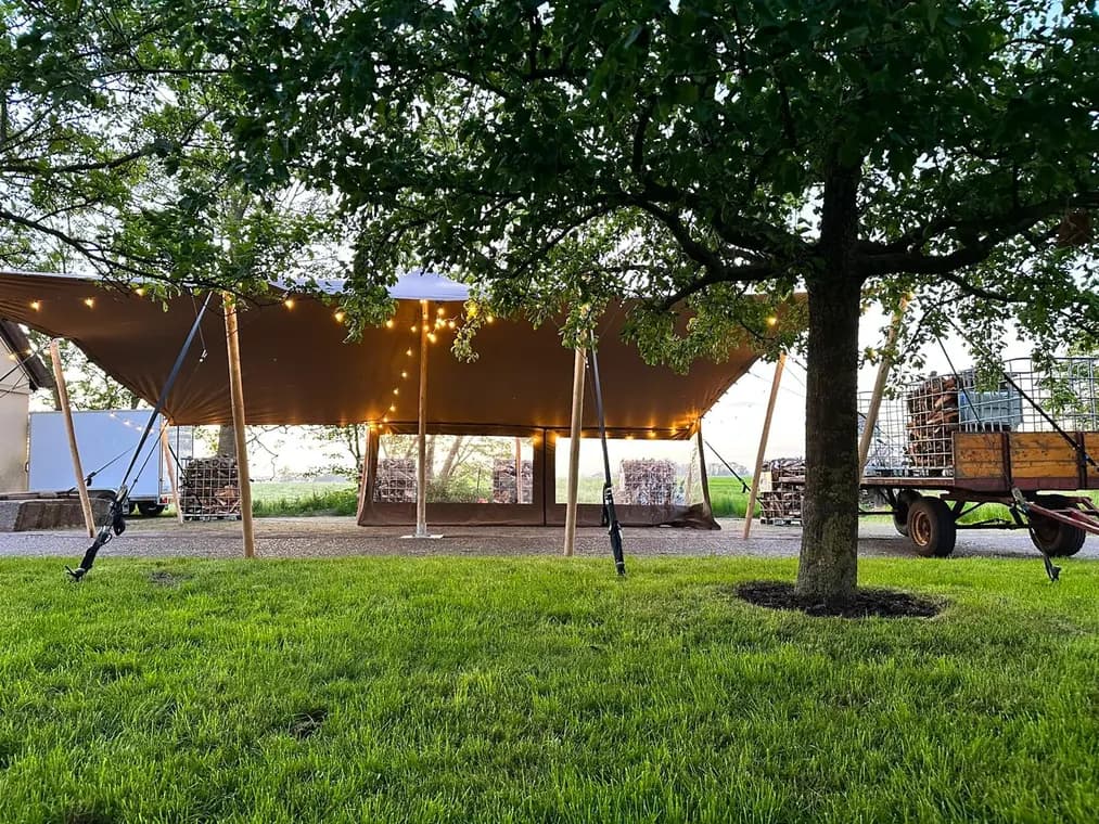 Stretchtent met sfeerverlichting tussen de bomen