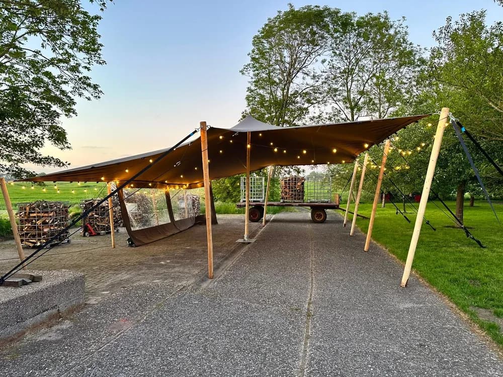 Stretchtent met sfeerverlichting tussen de bomen